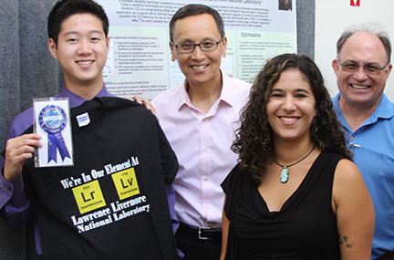 Julia Ramirez smiling as her summer student receives an award at Student Poster session