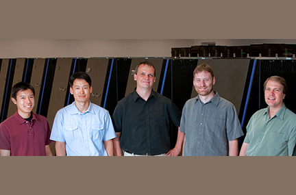 five people in front of a supercomputer