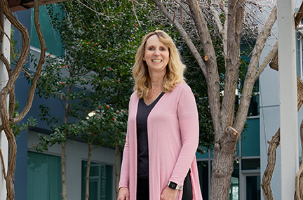 Kim standing outside a building with twisty trees