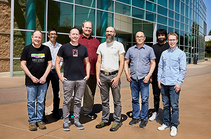 Flux team members posed as a group outside building 453