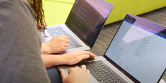 two interns work at their laptops