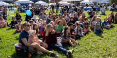 crowd sitting on a lawn