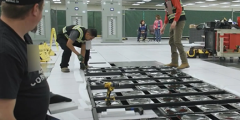 three people install an El Capitan components in the machine room