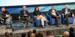 five panelists on a stage in front of an audience