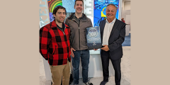 three people pose with the award